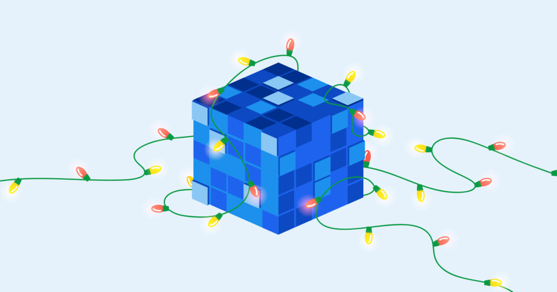 A blue cube covered in a green string of holiday lights that are red and yellow.